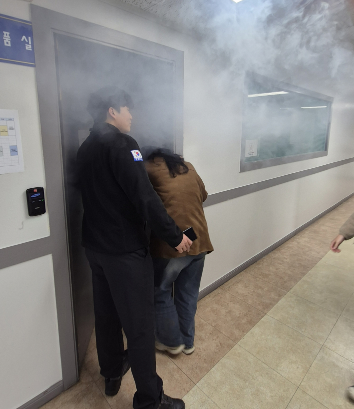 대피훈련을 진행하기 위해 연기가 가득한 실내로 들어가고 있다.