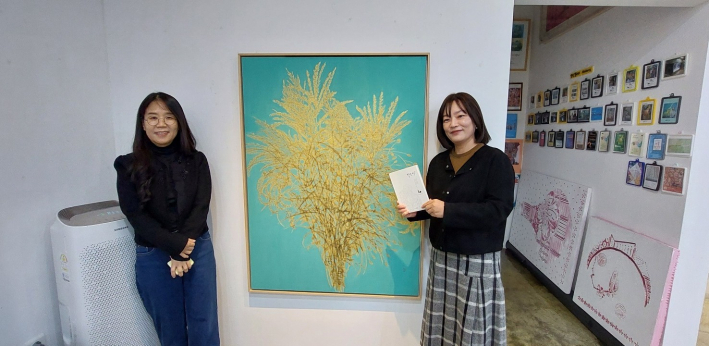 성민우 작가(왼쪽)가 자신의 작품앞에서 미술 애호가와 포즈를 취했다.