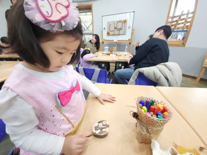 나뭇가지로 목공풀을 바르고 있는 딸아이 모습