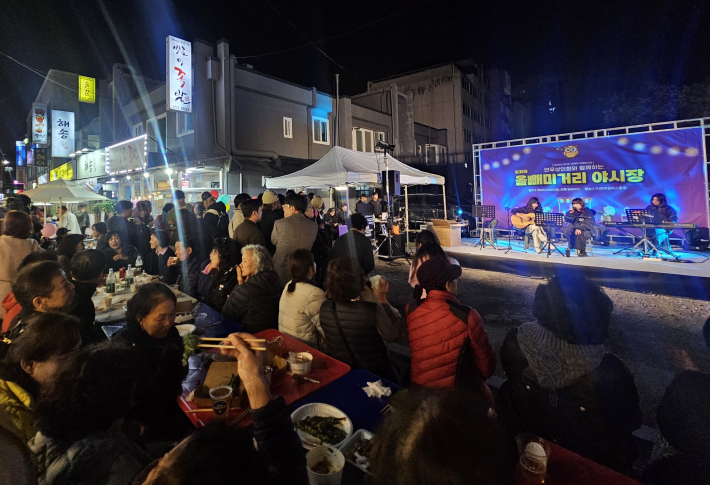늦은 밤, 주민들이 올빼미거리 야시장 행사를 즐기고 있다.