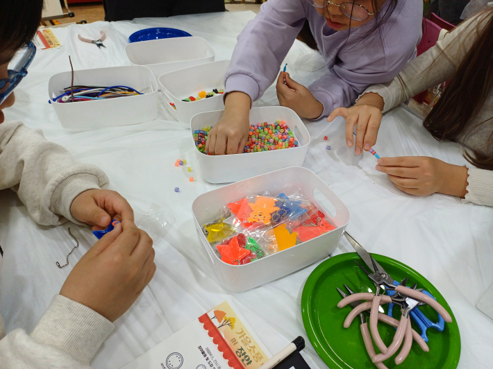 안전 키링 제작하는 어린이들의 손 동작