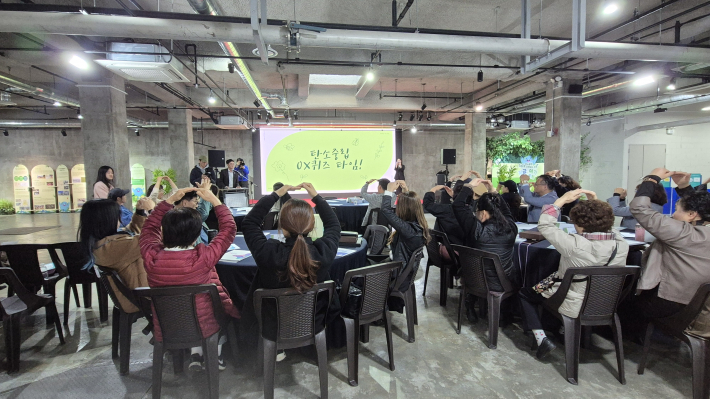 참여자들이 머리 위로 O와 X를 들고 퀴즈에 참여하고 있는 모습. 활기찬 에너지가 행사장을 가득 채웠다.