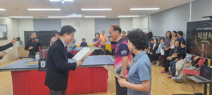 탁구 우승으로 상을 받는 사람들