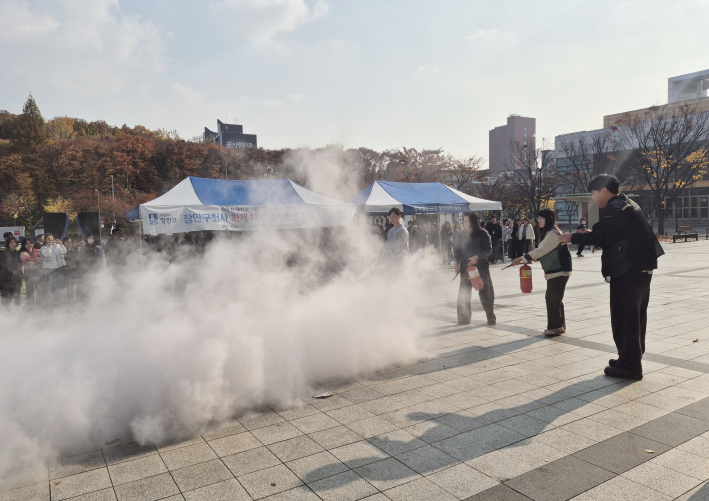 장안구청 직원들이 광장에서 소화기로 초기진화 훈련을하고 있다