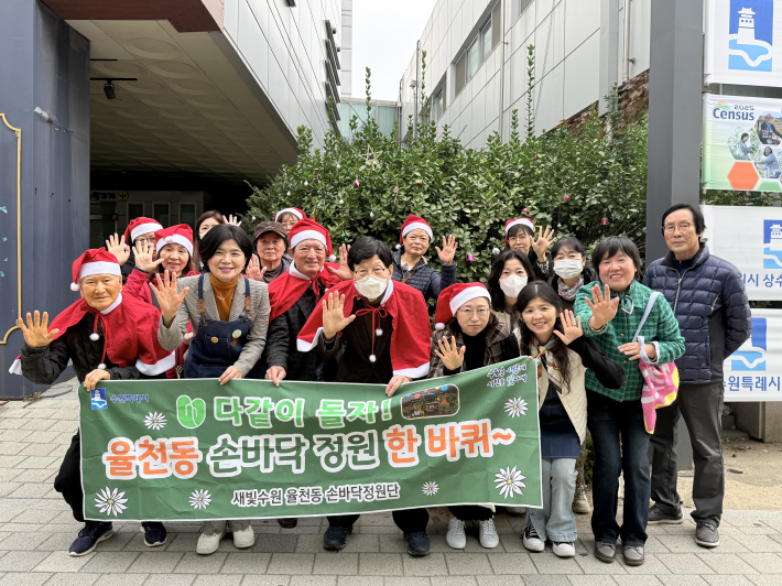 손바닥정원 행사에 참여한 성영신 율천동장과 김미진 손바닥정원단 대표, 주민들이 포즈를 취하고 있다.