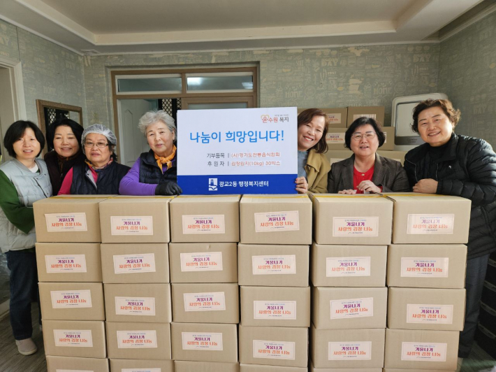 (사)경기도전통음식협회로부터 김장김치를 전달받는 모습.