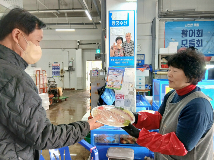 광교 두산위브에 거주하는 김용주 씨가 미리 포장해 놓은 회세트를 구매하고 있다.
