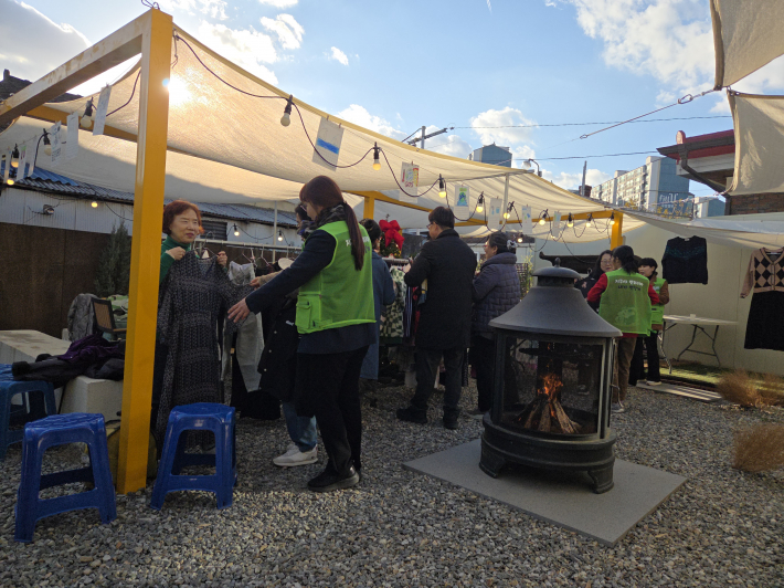 전시된 옷을 고르고 있는 주민들