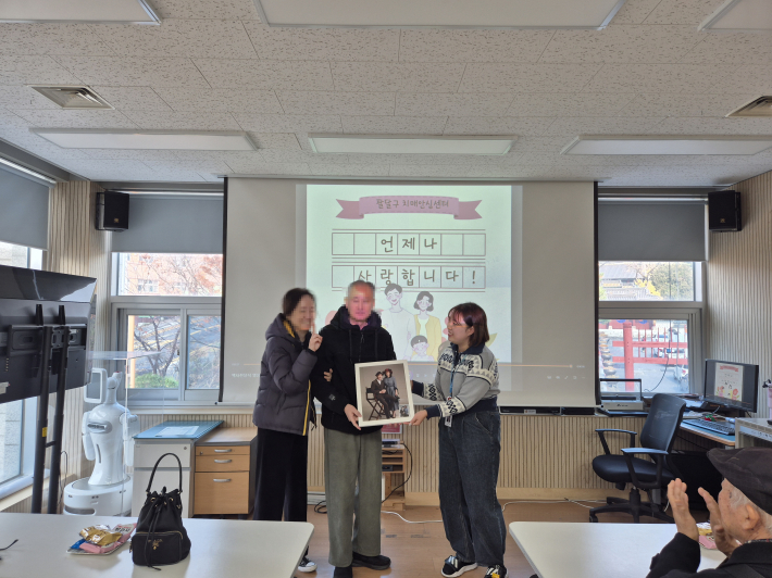 액자를 전달받고 기념촬영을 하고 있는 모습