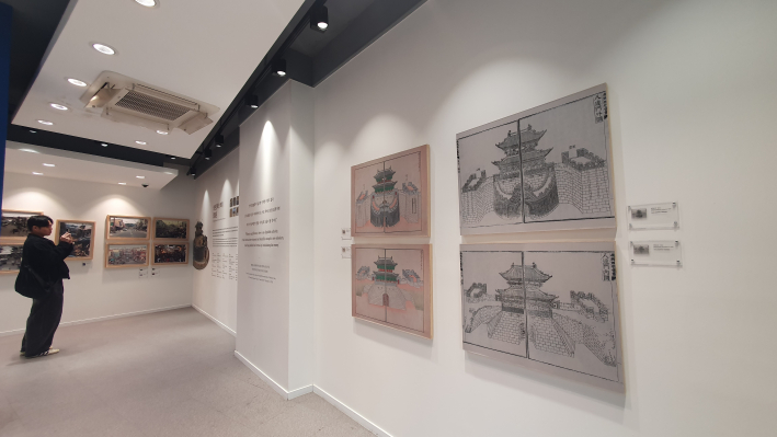 한 관람객이 팔달문의 옛 모습을 담은 그림과 사진 자료를 유심히 살펴보고 있다