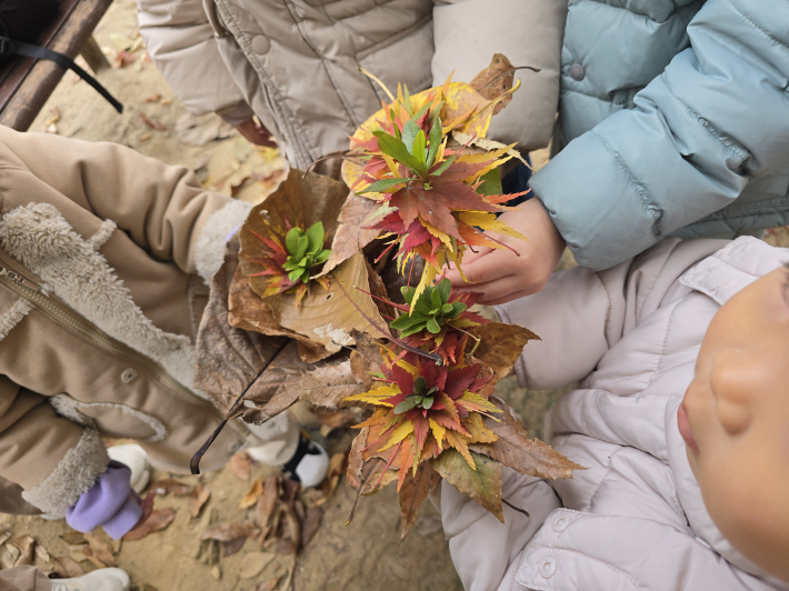 각자 주운 단풍잎을 모아 자연물이 예쁘게 어우러진 '단풍 꽃다발'을 만든 아이들