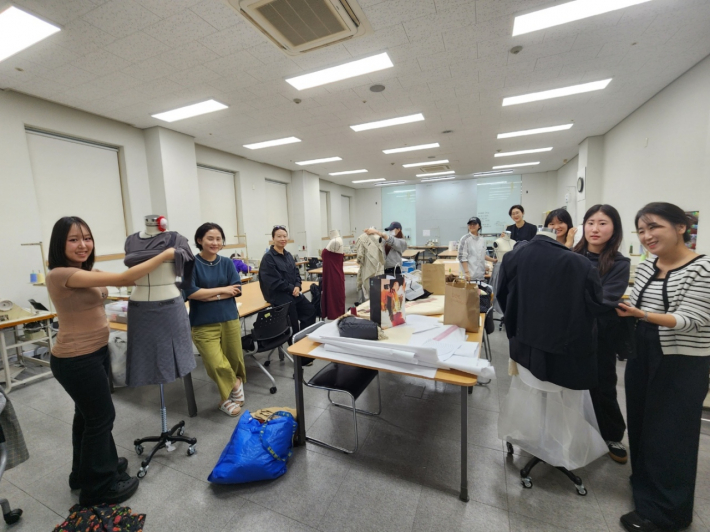 폐의류를 재구성해 새로운 패션 작품으로 재탄생시키는 과정에 학생들과 함께(사진:수원여자대학교 제공)  