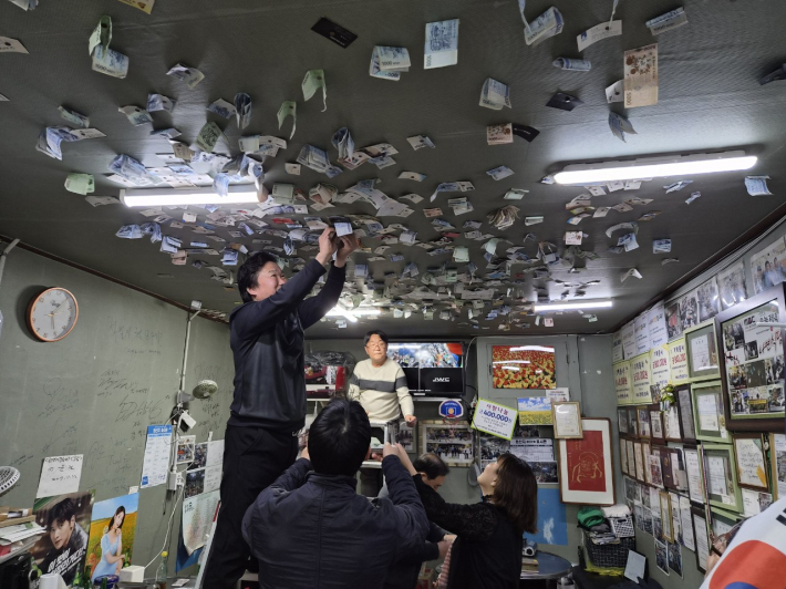 손님들이 나연식당 천장에 붙인 봉사료를 십시일반 모으다