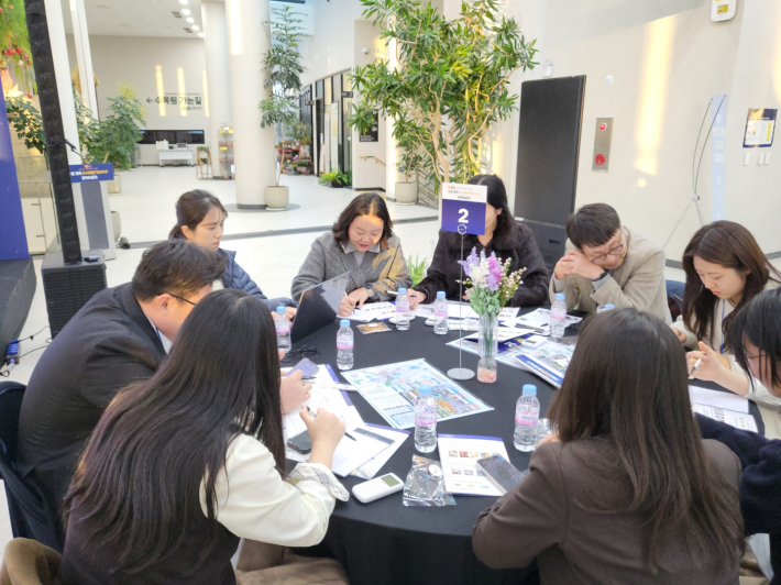 각 테이블에서 좋은 아이디어를 내기 위해 머리를 맞대고 논의하고 있다.