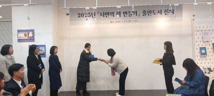 류영신 관장이 작가들에게 책을 증정하고 있다.