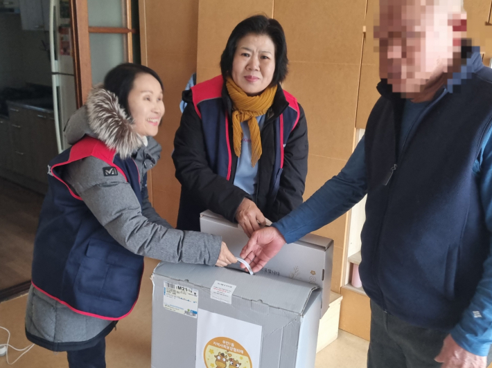 우만1동 지역사회보장협의체 위원들이 전기장판 선물을 전달하고 있다