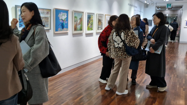 삼삼 오오 모여 작품을 감상하는 관중들...