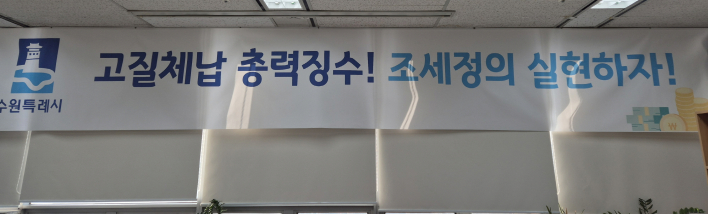 '고질체납 총력 징수! 조세정의 실현하자!' 수원시 징수과 사무실에 걸려 있는 현수막.