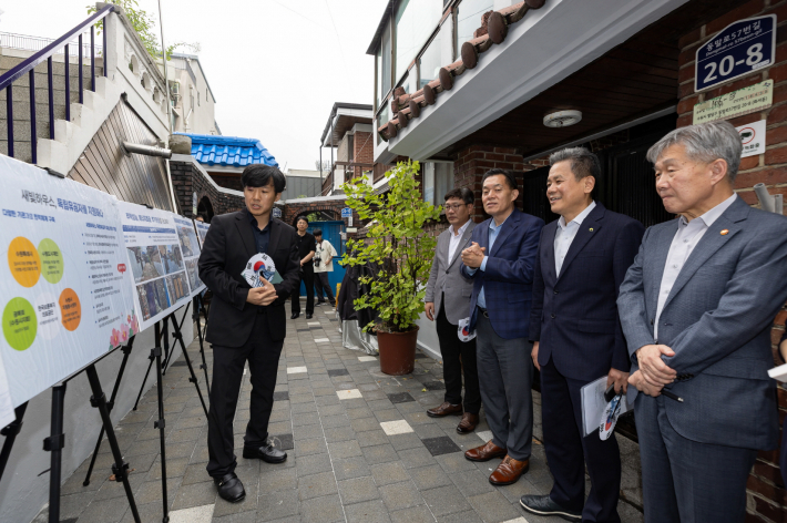수원시와 한국보훈복지의료공단이 수원지역 독립유공자 후손의 집수리를 지원한 새빛하우스 앞에서 관계자들이 사업 설명을 듣고 있다