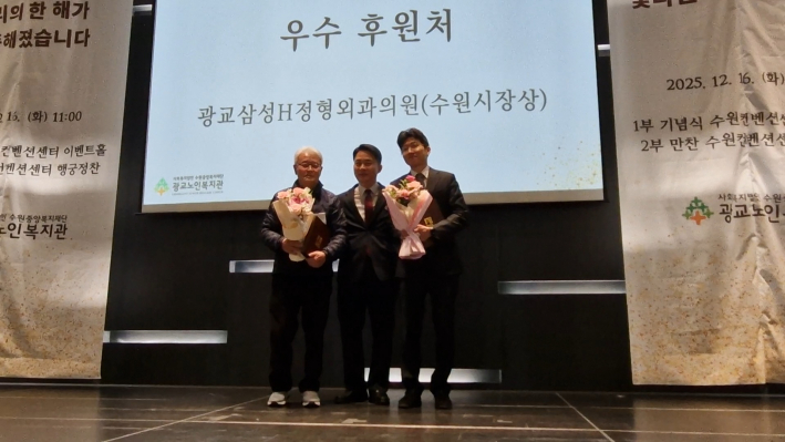 수원시장상을 수상한 자원봉사자 홍 경수, 우수 후원 처 광교삼성정형외과의원이 기념 촬영을 하고 있다