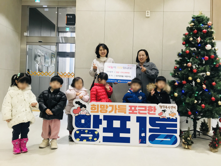 블루밍의뜰어린이집 원생들이 함께 참여하여 성금을 기탁하며 기념촬영을 하고 있다