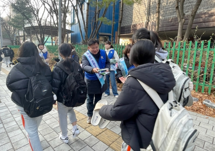 바르게살기운동위원회에서 학생들에게 유해환경 금지 문구가 부착된 핫팩을 나눠주고 있다.