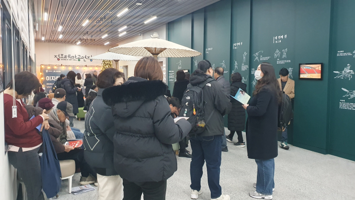 공연 시간이 임박하자 로비가 관객들로 북적이고 있다. 관객들이 삼삼오오 모여 팸플릿을 보며 입장을 기다리는 모습.