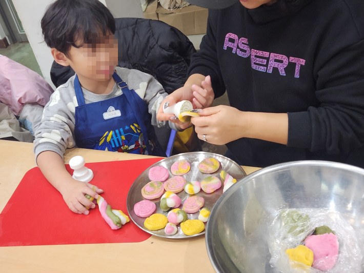 엄마와 함께 떡 모양을 만드는 이도윤 어린이