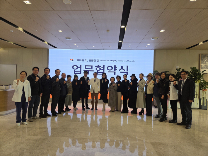 협약식 후 기념촬영에서 관련기관 관계자들이 손을 들고 있는 장면(사진:협회 제공)