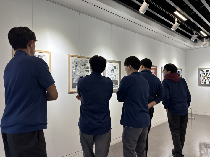 영통구 사회복무요원들이 전시회 미술작품을 관람하고 있다.