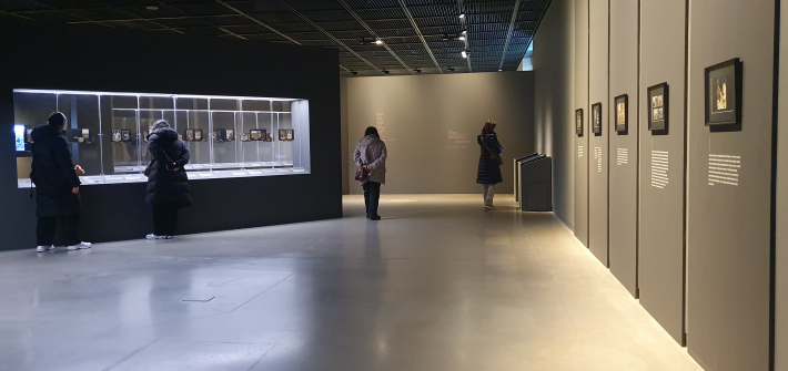 나혜석의 사진첩을 자세히 들여다보고 있는 관람객들