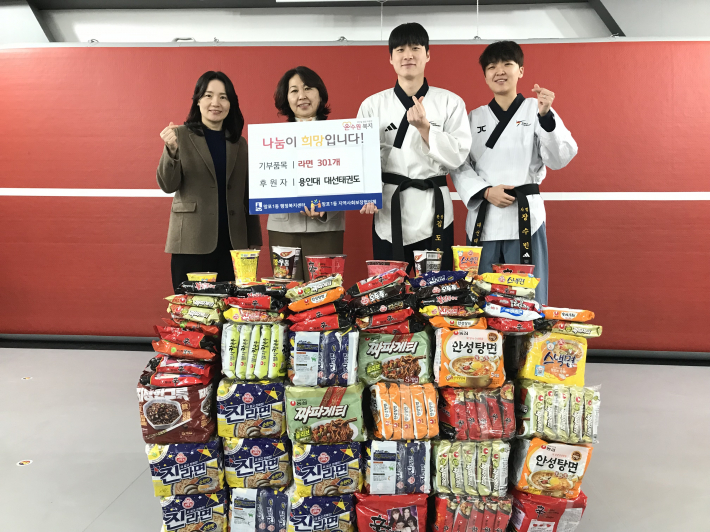 용인대대선태권도 김도욱 관장(중앙 오른쪽)과 김영희 망포1동장(중앙 왼쪽)이 후원한 물품을 놓고 기념촬영을 하고 있다