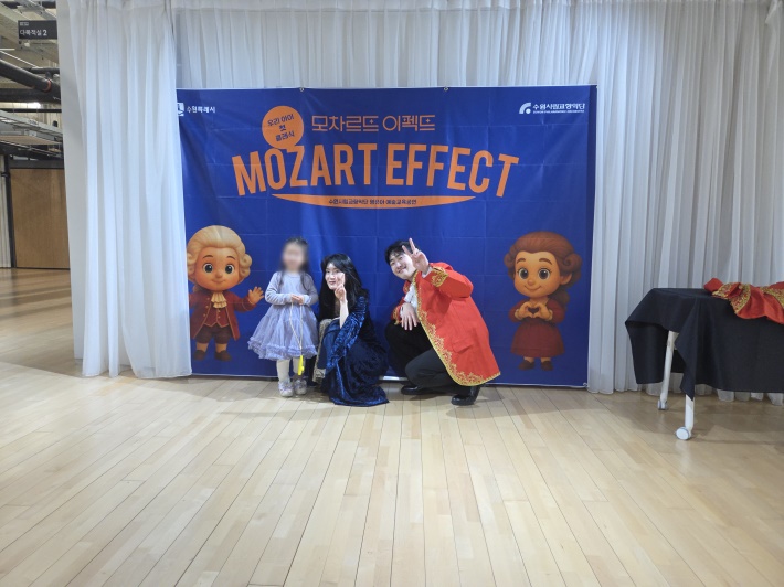 공연 진행자들이 한 어린이와 기념사진을 찍고 있다.