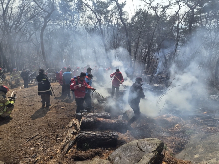 지난 12일 팔달산 화재 현장에서 잔불을 정리하는 모습.