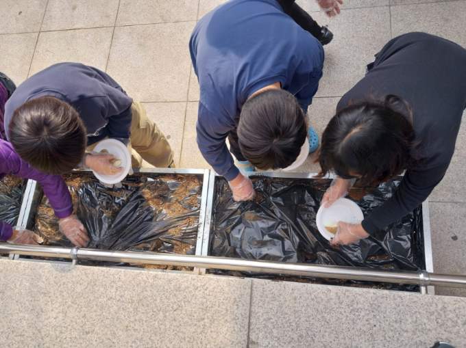 어린이들이 마을문고 앞 상자 텃밭에서 씨감자를 심고있다.