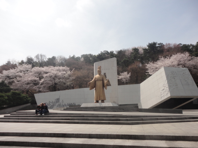 정조대왕 동상앞에 앉아 기념촬영하는 상춘객