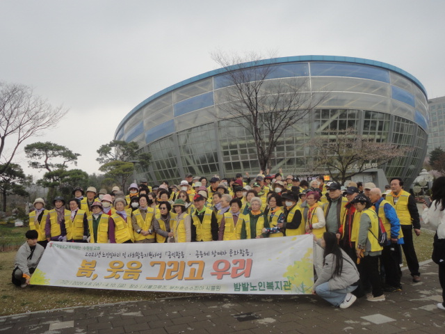 식물원을 배경으로 기념촬영하는 밤밭노인복지관 노인들 