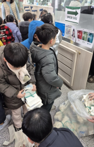 원아들이 우유팩 및 폐건전지를 교환하고 있다