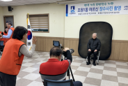이만세 한식부 봉사회원이 조원1동에서 장수사진을 촬영하고 있다.