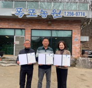 연무동 관계자들이 폭포농원 앞에서 업무협약서들 들고있다.