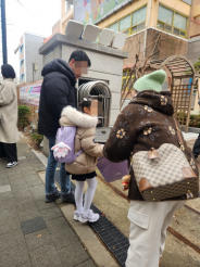 초등학교 새내기들이 입학식 날 교문에서 출석통장을 받고있다.