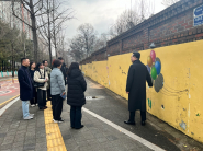 정자3동 주민자치회가 장안구 하률로12번길 일대 노후 외벽 정비를 위해 현장점검을 하고 있다.