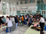 주민들이 직접 딸기를 으깨며 딸기청 만들기 체험을 즐기고 있는 모습