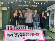 헤라 건강학교 7기 봉사회와 새마을부녀회가 세류3동 공유냉장고에 반찬을 기부하고 기념촬영을 하고 있다.