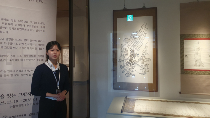 김송희 도슨트가 성덕대왕신종 비천상 탁본 옆에서 해설을 하고 있다. 육안으로는 잘 보이지 않는 미세한 문양이 탁본을 통해 드러남을 설명한다.