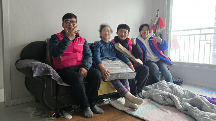 협의체 위원들이 가정방문하여 어르신에게 전기장판을 전달하고 있다. 