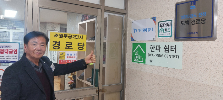 경로당 입구에서 포즈를 위한 최병현 회장. 오른쪽에 모범경로당 대상 현판이 보인다.