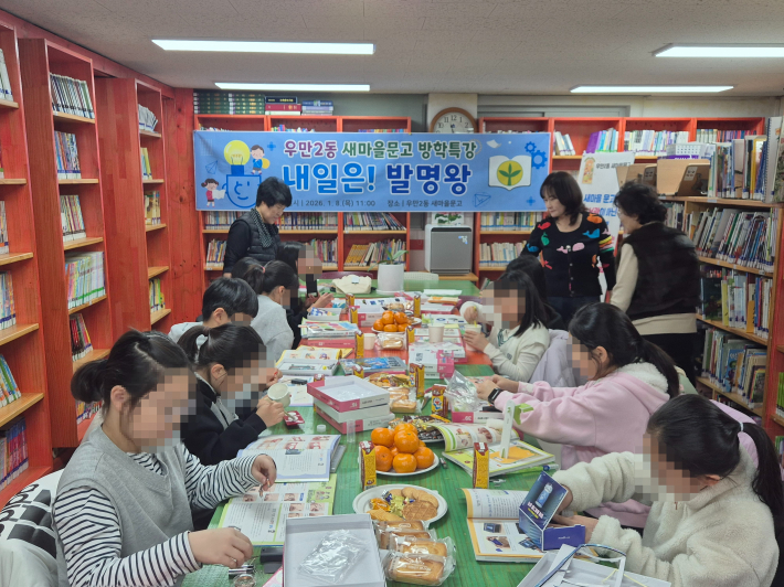 학생들이 책을 읽으며 발명키트를 만들어보고 있다