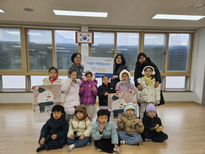 해보듬어린이집에서 원아들과 함께, 광교2동 행정복지센터에 기부금을 전달하는 모습.