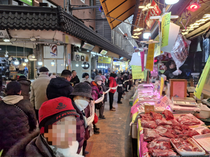 두 줄로 나온 가래떡을 사람들은 비닐로 싸서 받았다. 